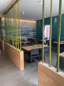 a restaurant with wooden tables and chairs and bamboo poles at MAR60 Apartments in Caorle