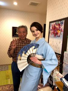 a man holding a woman's hand while standing in a room at Tokyo Guest House 2020 in Tokyo