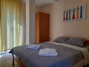 a bedroom with a bed with two towels on it at BATO Rooms in Pe&scaron;tani