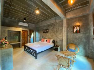 Nan Arena Place في نان: غرفة نوم بسرير وكراسي في غرفة
