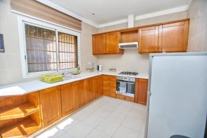 a kitchen with wooden cabinets and a sink and a refrigerator at Appartement - Vue sur mer in Pointe-Noire