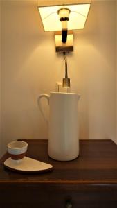 a lamp on a table with a cup on a table at Hotel Tourist in Parga