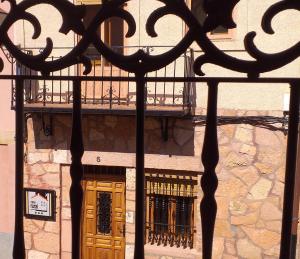 un edificio con balcone e porta in legno di BOTEROS casa rural ad Ayllón