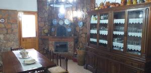 a dining room with a table and a cabinet with wine bottles at BOTEROS casa rural in Ayllón