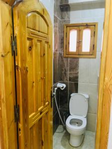 a bathroom with a toilet and a wooden door at Villa 22 in Dahab +37 photos