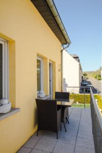 a patio with a table and chairs on a balcony at Gästehaus Edith, 4-Sterne für 2 Personen in Trittenheim