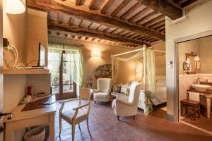 a bedroom with a bed and a desk and chairs at La Melosa Resort & Spa in Roccastrada