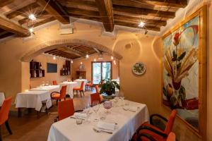 una sala da pranzo con tavoli bianchi e sedie arancioni di La Melosa Resort & Spa a Roccastrada