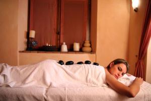 una mujer acostada en la cama bajo una manta en La Melosa Resort & Spa, en Roccastrada