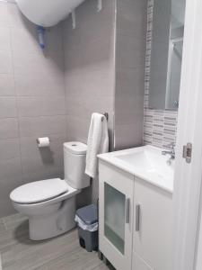 a white bathroom with a toilet and a sink at Estudio FARO TORROX-1ª línea playa in Torrox Costa