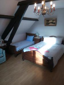 1 dormitorio con 2 camas y lámpara de araña en B&B Ter Castaigne, en Koekelare