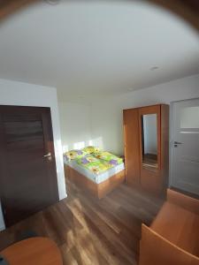 ein kleines Schlafzimmer mit einem Bett und einer Tür in der Unterkunft AGAT Pokoje Gościnne Apartamenty in Pobierowo
