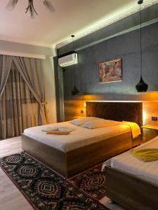 1 dormitorio con 2 camas y alfombra en Hotel Jurgen en Lezhë