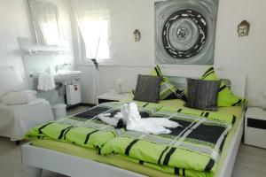 um quarto com uma cama verde e um lavatório em Gästehaus Edith, 4-Sterne, 2-4 Personen em Trittenheim