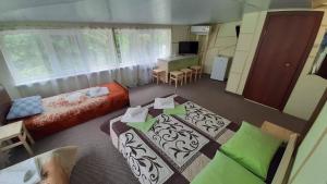 ラザレフスコエにあるГостевой дом Море и Горыのベッドとテーブルが備わる小さな客室です。
