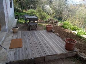 une terrasse en bois avec une table de pique-nique et un banc dans l'établissement La Mésange Charbonnière, à Lucéram