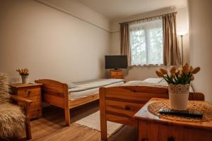 a bedroom with two beds and a table and a window at Your Apartment in Makó