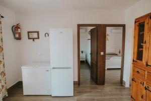 eine Küche mit einem weißen Kühlschrank im Zimmer in der Unterkunft El Galindón Rancho in La Puebla de los Infantes