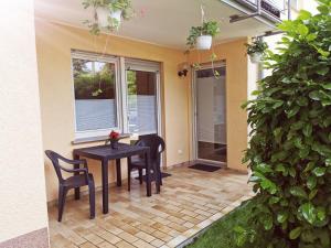 a patio with a table and chairs and a window at Ferienwohnung Am Michelsbach in Boppard
