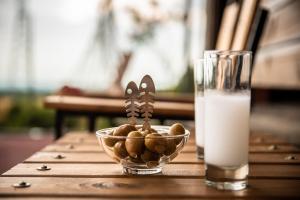 a bowl of nuts on a table next to a glass of milk at ΛΩΤΟΣ in Kavála