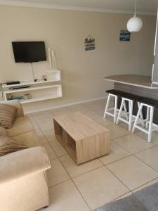 uma sala de estar com um sofá e uma mesa em 84 Camarque Umdloti beach em Umdloti