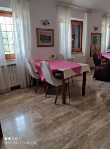a dining room with a pink table and chairs at B&B Joy in Colleferro