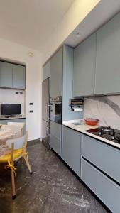 una cucina con armadi bianchi, tavolo e sedia di Sapore di Mare Apartment a Monterosso al Mare