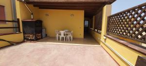 un balcone di una casa con tavolo e sedie di Appartamento in Centro a Lampedusa