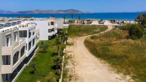 a beach with houses and cars parked on it at Mythos Hotel Apartments in Tigaki