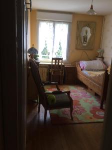 a bedroom with a chair and a bed and a window at St Yves in Rennes