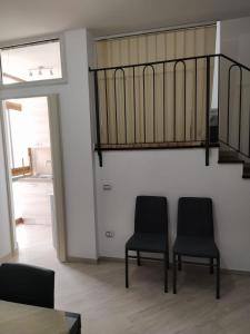 - deux chaises noires dans une chambre avec un escalier dans l'établissement la casa di sara, à Quartu SantʼElena