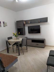 a living room with a table with chairs and a tv at la casa di sara in Quartu SantʼElena