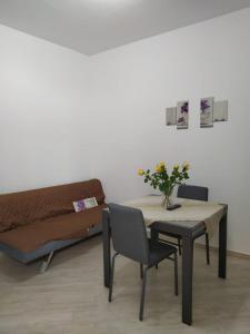 une table avec un vase de fleurs et un lit dans l'établissement la casa di sara, à Quartu SantʼElena