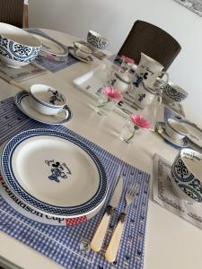 a table with blue and white plates and utensils at Residentie Rapallo Oostende with fantastic Sea View! in Ostend