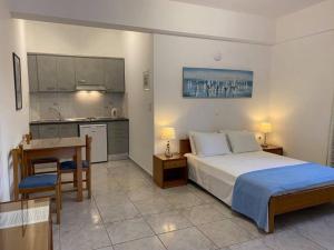 ein Schlafzimmer mit einem Bett und einem Schreibtisch sowie eine Küche in der Unterkunft Villa Anna Maria in Mylopotas