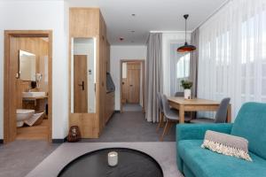Apartmány Bachledka في زديار: غرفة معيشة مع أريكة زرقاء وطاولة