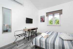 a white bedroom with a bed and a desk at VILLA SANDRINA in Vrh +36 photos