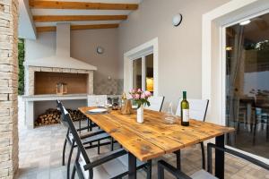 a dining room with a wooden table and a fireplace at VILLA SANDRINA in Vrh