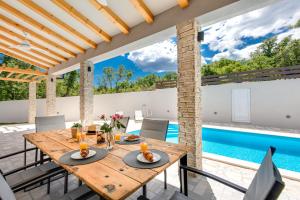 a dining room with a table and a swimming pool at VILLA SANDRINA in Vrh