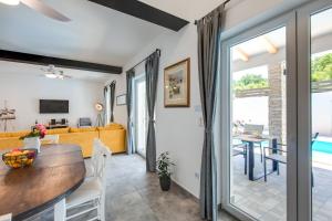 a dining room and living room with a table and chairs at VILLA SANDRINA in Vrh