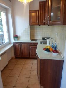 una cucina con mobili in legno e una ciotola di frutta sul bancone di Pokoje Ustka Pogodna 12 a Ustka