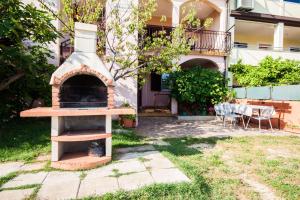 a brick oven in the yard of a house at Apartments Dara in Umag