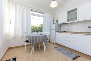 a kitchen with a table with chairs and a window at Apartments Biserka in Božava +30 photos