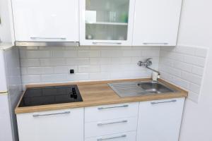 a kitchen with white cabinets and a sink at Apartments Biserka in Božava