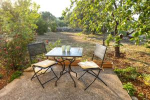 a table with two chairs and a table with glasses on it at Apartments Biserka in Božava
