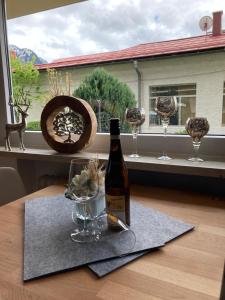 eine Flasche Wein und Gläser auf einem Tisch mit Fenster in der Unterkunft Alpenflair Ferienwohnung 111 Nebelhorn in Oberstdorf