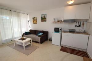 a kitchen and a living room with a couch and a table at Apartment Luigi in Poreč