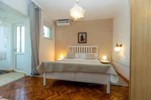 a bedroom with a bed and two lamps and a door at Apartments Biserka in Božava