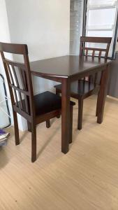 a wooden table with two chairs and a wooden table and chairs at Mplace Condo Unit _ Panay Avenue, Quezon City, Philippines in Manila