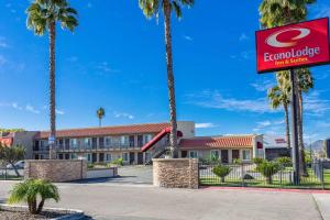 a hotel with palm trees in front of a building at Econo Lodge Inn & Suites Escondido Downtown in Escondido